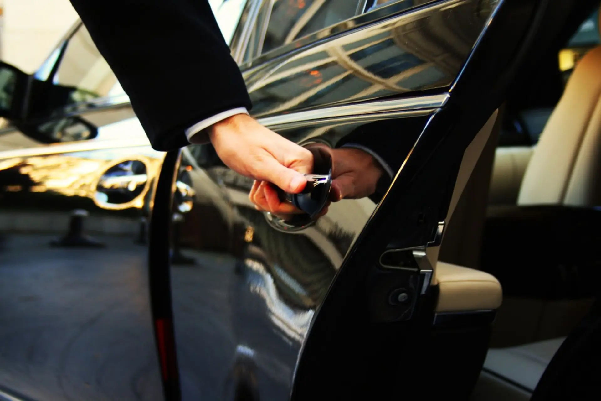 Professional chauffeur opening car door — Aurora O'Hare and Midway airport transfers